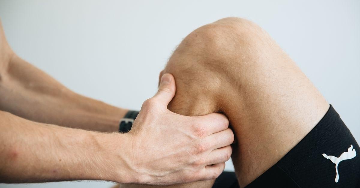 Detailed image of a physiotherapy session focusing on knee massage treatment.