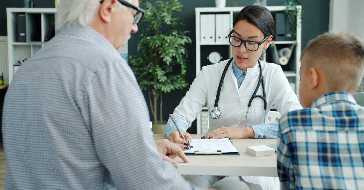 Medical consultation with a doctor, senior man, and child in a clinic setting.
