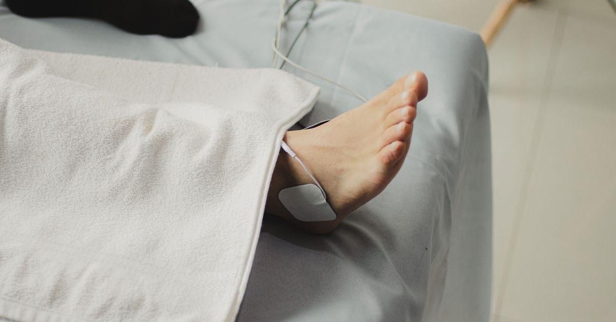 A close-up image of a bare foot with a medical electrode, suggesting a healthcare setting.