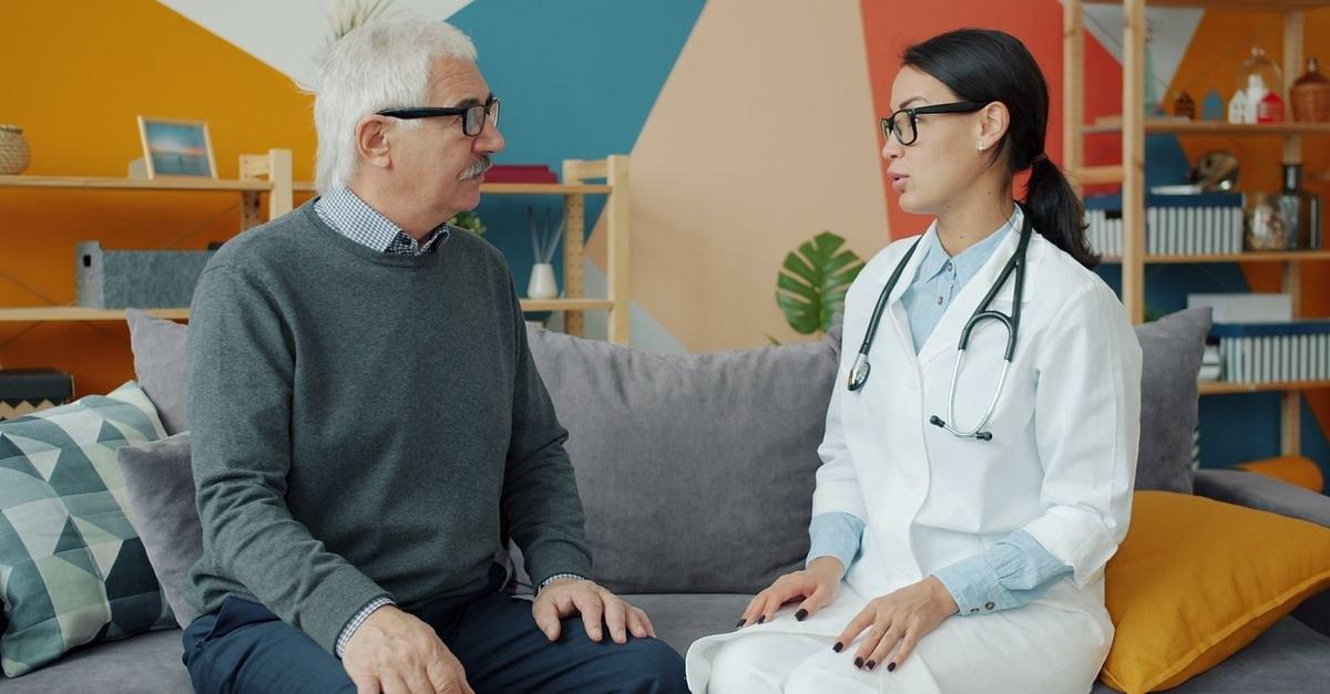 Senior man consulting with female doctor in a colorful office setting.